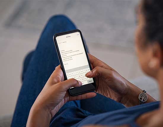 Woman sending email from mobile phone